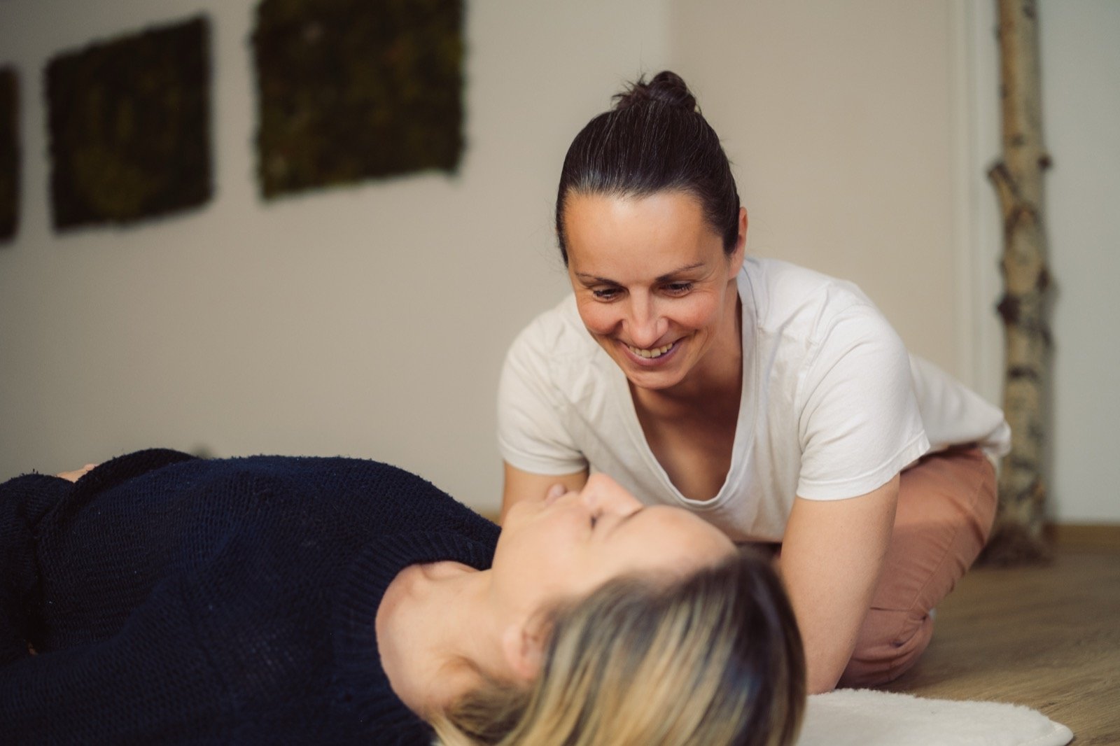 Nadine begleitet achtsam eine liegende Klientin während einer Breathwork-Session